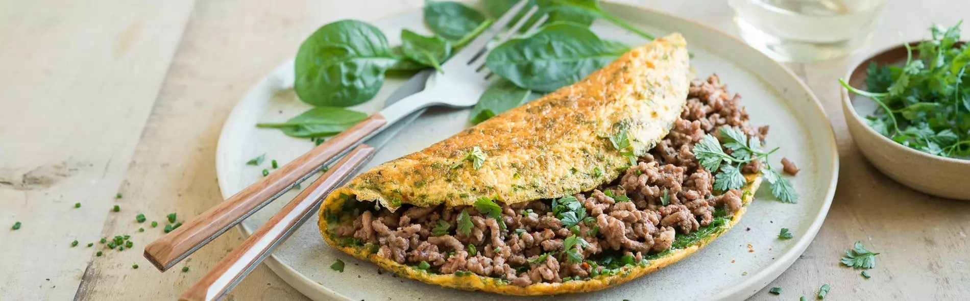 Omelette aux herbes, haché de bœuf et pousses d’épinards